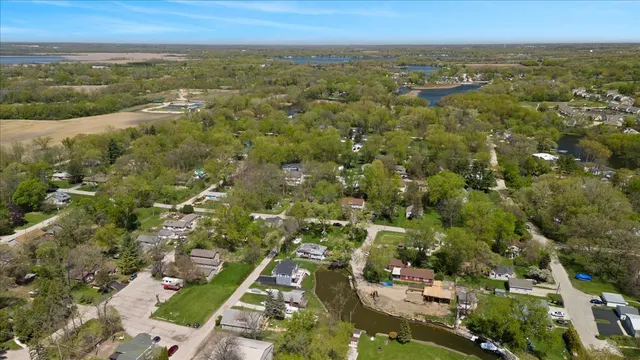an aerial view of residential houses with outdoor space and trees