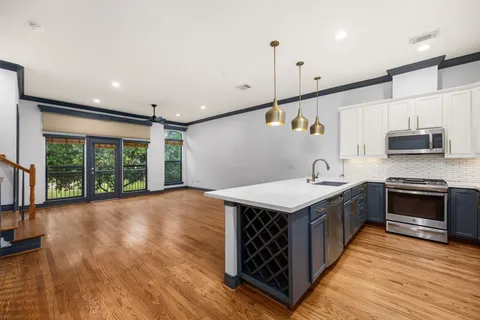 a kitchen with stainless steel appliances granite countertop a stove a sink and a refrigerator