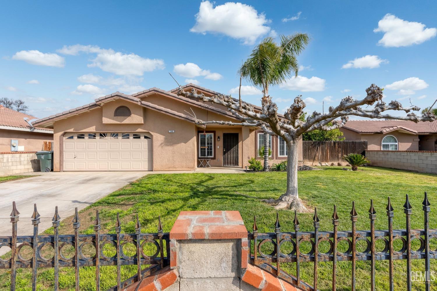 Undisclosed Address Arvin, CA 93203 - Photo 2 of 33 a front view of a house with a yard and garage