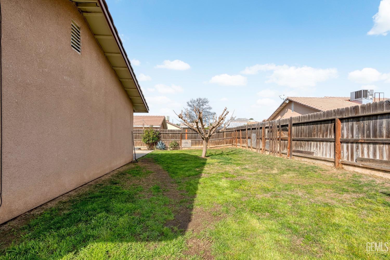 Undisclosed Address Arvin, CA 93203 - Photo 28 of 33 a view of a backyard with plants and wooden fence
