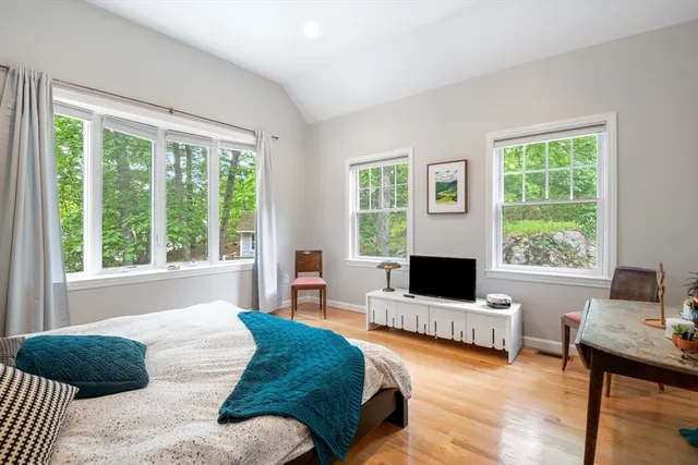a bedroom with a bed window and a flat screen tv