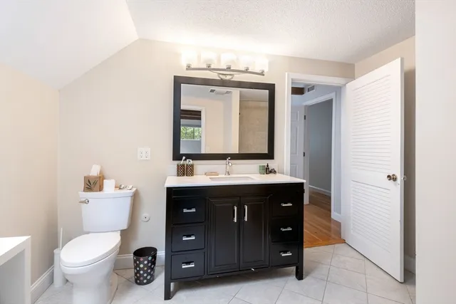 a spacious bathroom with a toilet sink and mirror