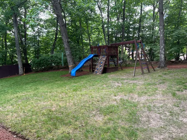 a view of a backyard with a slide and a table