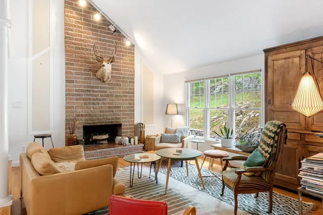 a living room with furniture a fireplace and a large window
