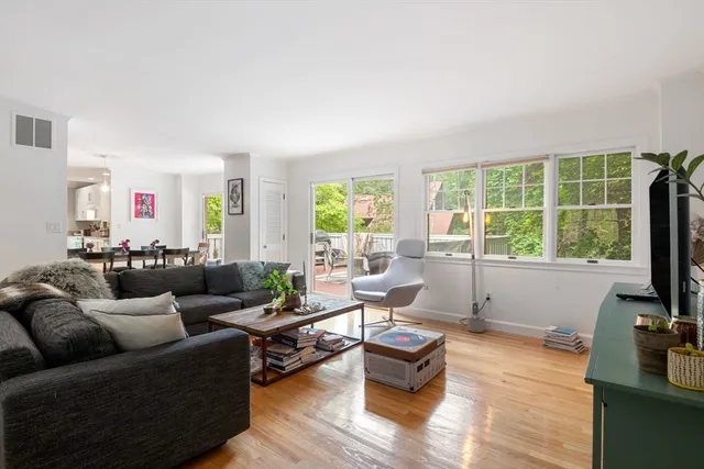 a living room with furniture flat screen tv and a large window
