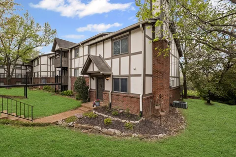 a view of a house with a yard and fence