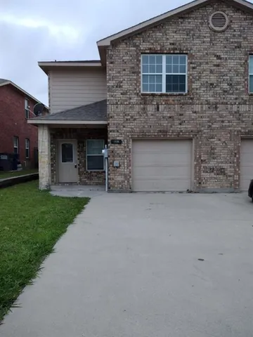 a front view of a house with a garden and yard