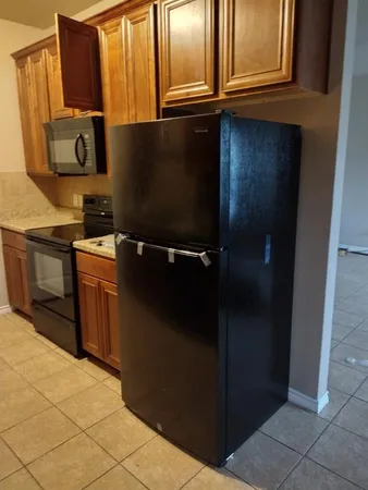 a kitchen with a refrigerator stove and cabinets