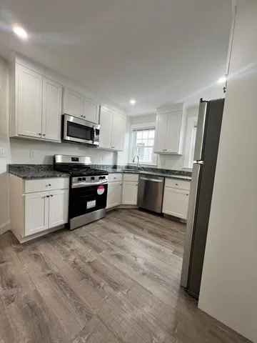 a large kitchen with cabinets stainless steel appliances and a sink
