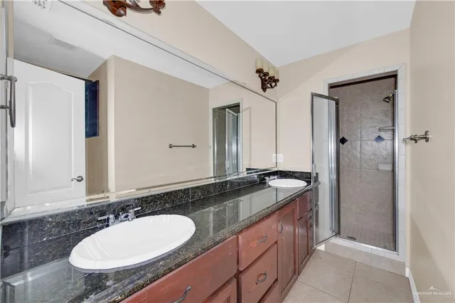a bathroom with a granite countertop sink and a mirror