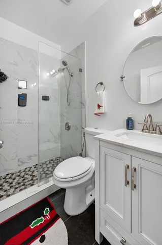 a bathroom with a sink toilet vanity and shower