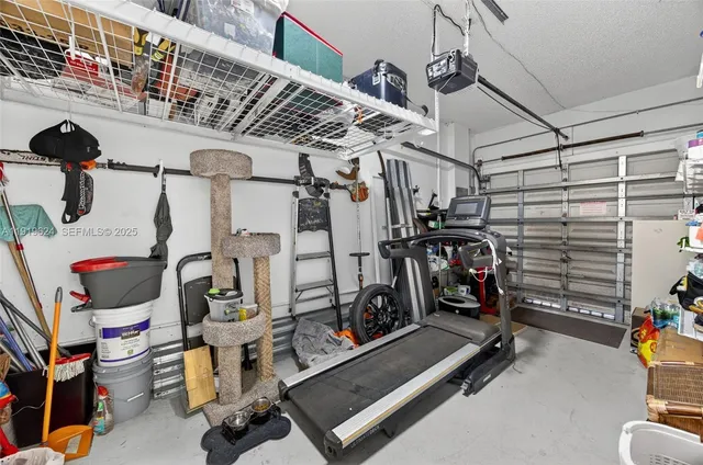 a bed room with a bed a computer on a desk and chair