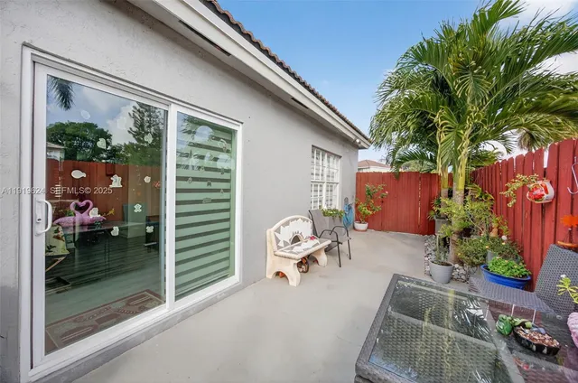 a backyard of a house with barbeque oven table and chairs