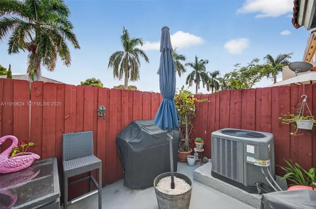 a backyard of a house with barbeque oven table and chairs
