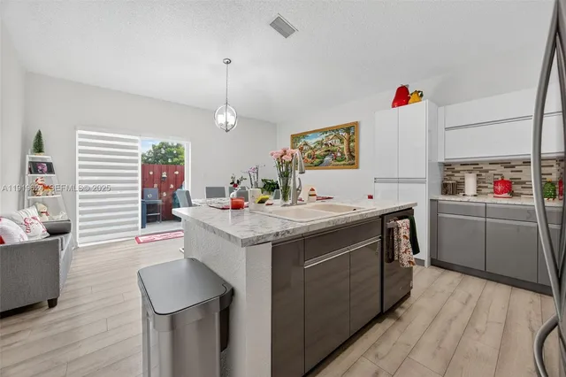 a kitchen with a sink stove and wooden floor