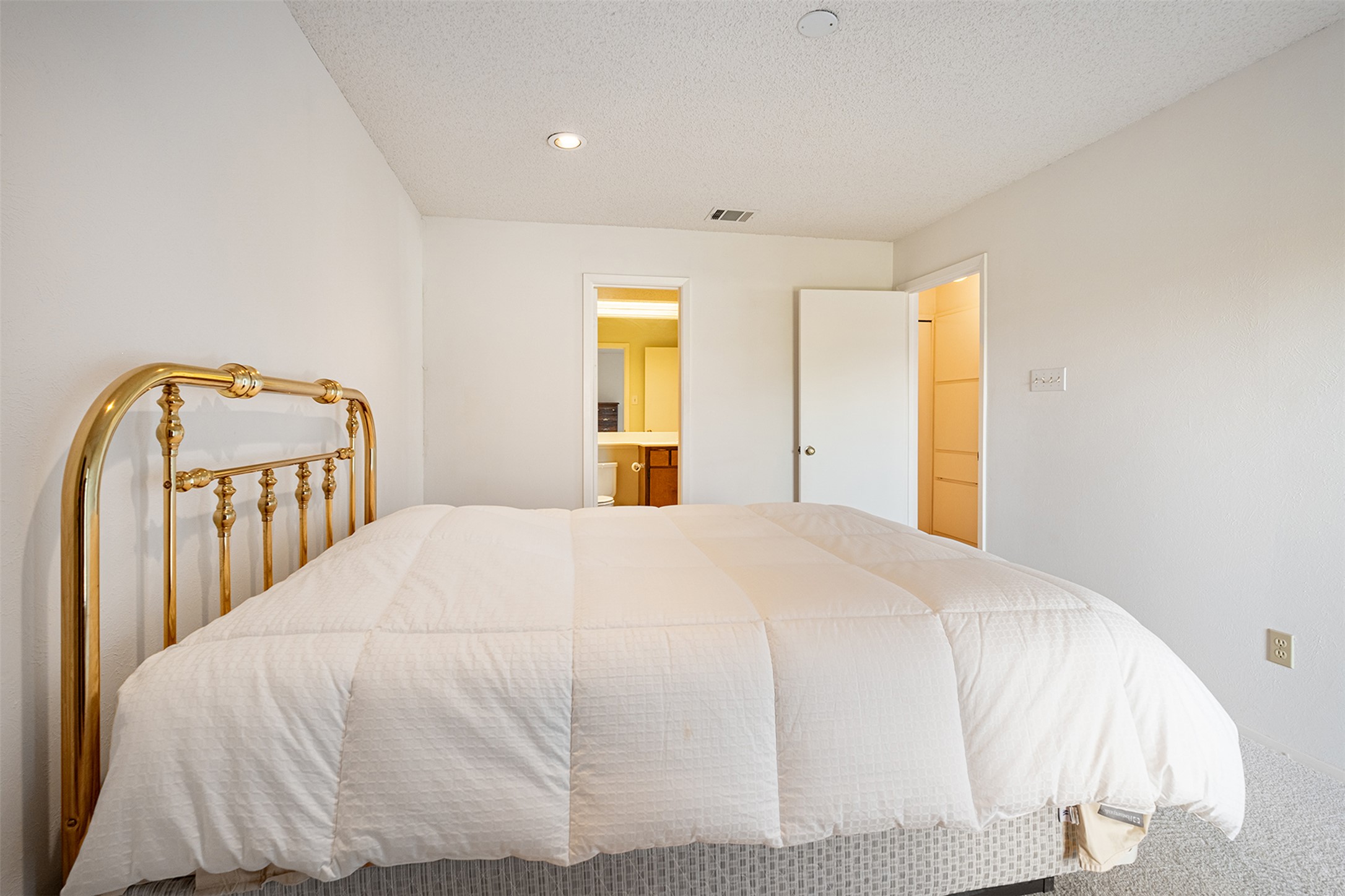 1748 Ohlen Road, Unit 16 Austin, TX 78757 - Photo 20 of 38 Bedroom featuring a textured ceiling, connected bathroom, and recessed lighting