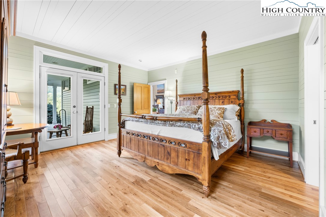 410-560 Puckett Road Banner Elk, NC 28604 - Photo 17 of 50 a bedroom with a bed lamp and wooden floor