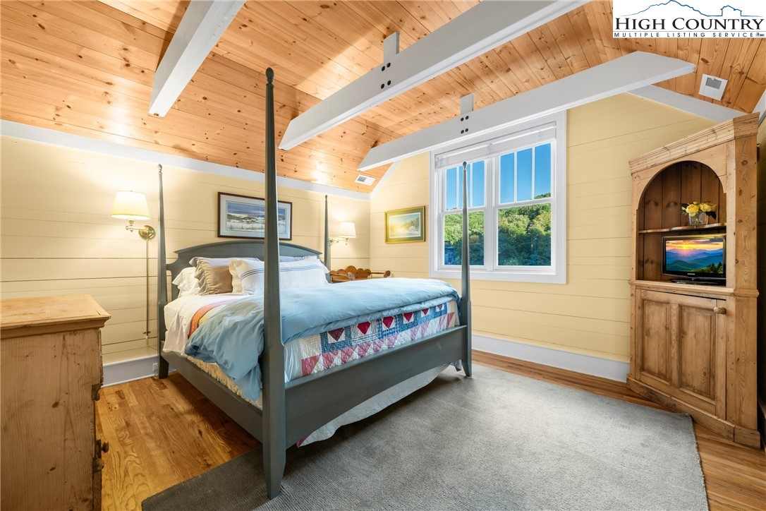410-560 Puckett Road Banner Elk, NC 28604 - Photo 22 of 50 a bedroom with a bed and a flat tv screen on wall