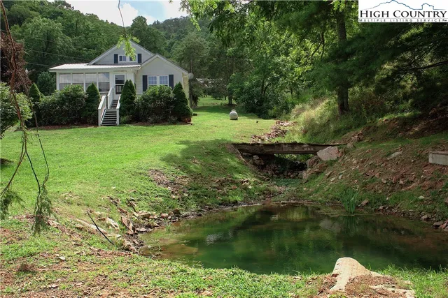a view of a house with a yard and a fountain