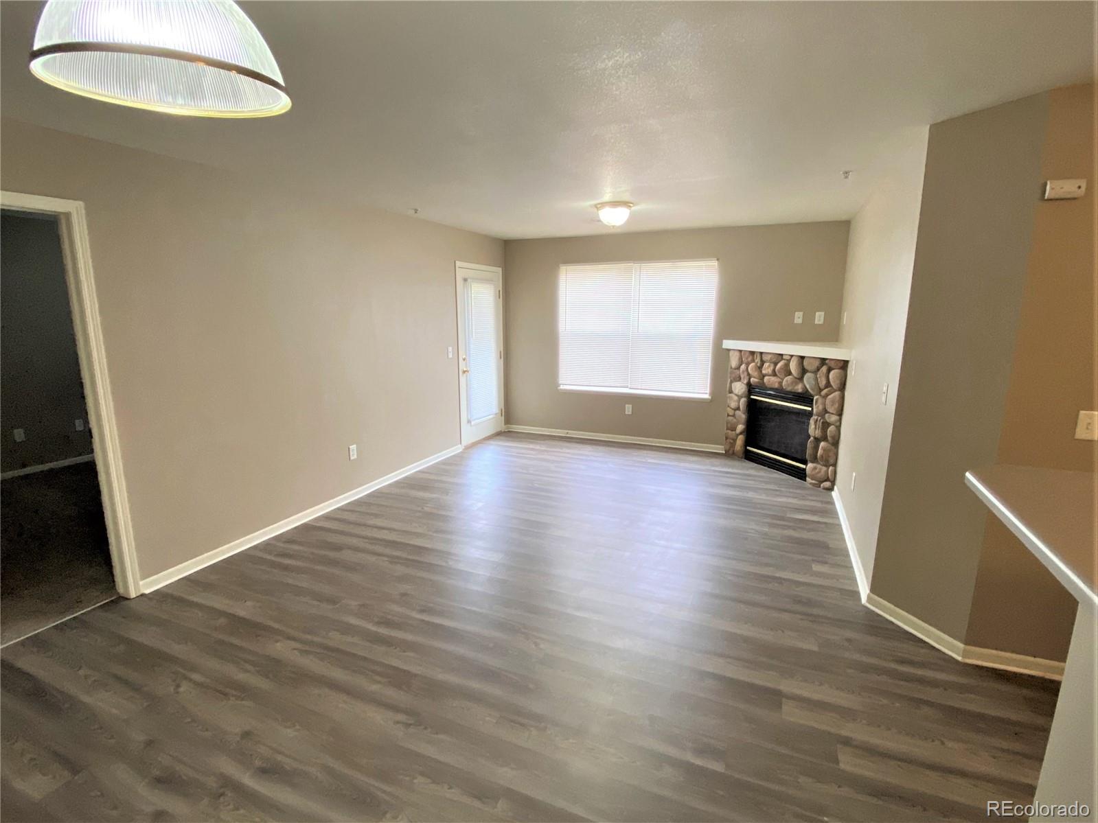 2226 West Elizabeth Street, Unit 202 Fort Collins, CO 80521 - Photo 4 of 9 an empty room with wooden floor and windows