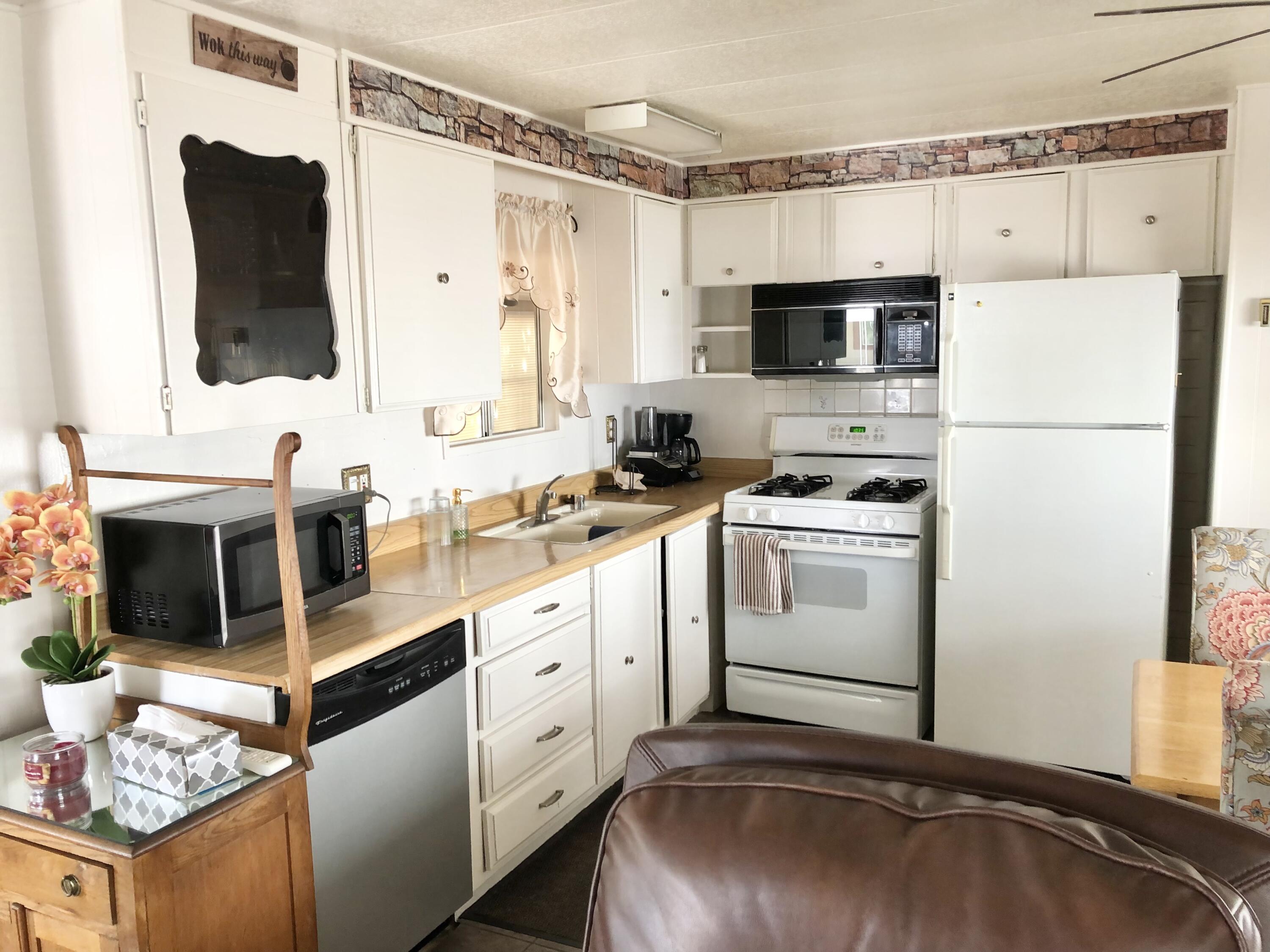 74711 Dillon Road Desert Hot Springs, CA 92241 - Photo 8 of 69 a kitchen with stainless steel appliances a stove sink and refrigerator