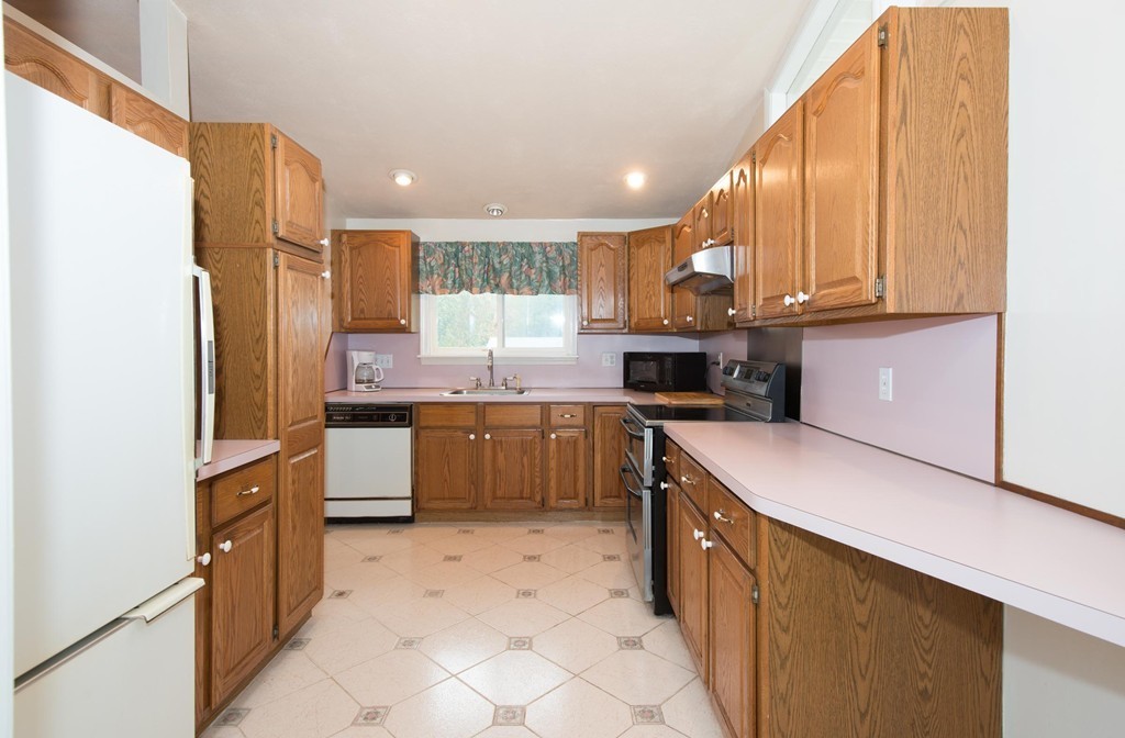 5 Fatima Road Stoneham, MA 02180 - Photo 6 of 20 a kitchen with stainless steel appliances granite countertop a sink counter space cabinets and a large window