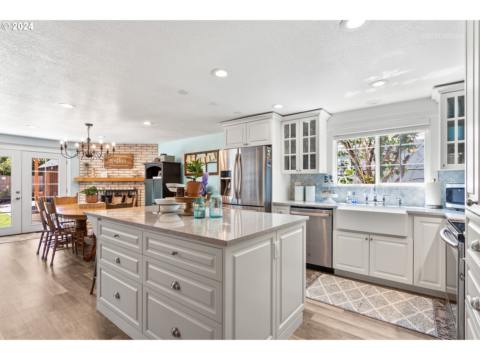 780 South Elm Court Canby, OR 97013 - Photo 11 of 32 a kitchen with kitchen island granite countertop a sink and cabinets
