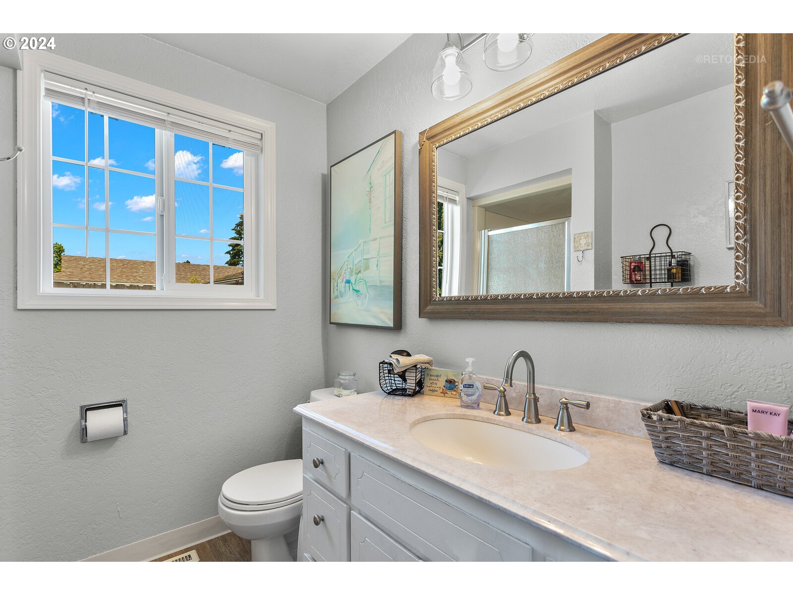 780 South Elm Court Canby, OR 97013 - Photo 21 of 32 a bathroom with a granite countertop toilet a sink a mirror and a window