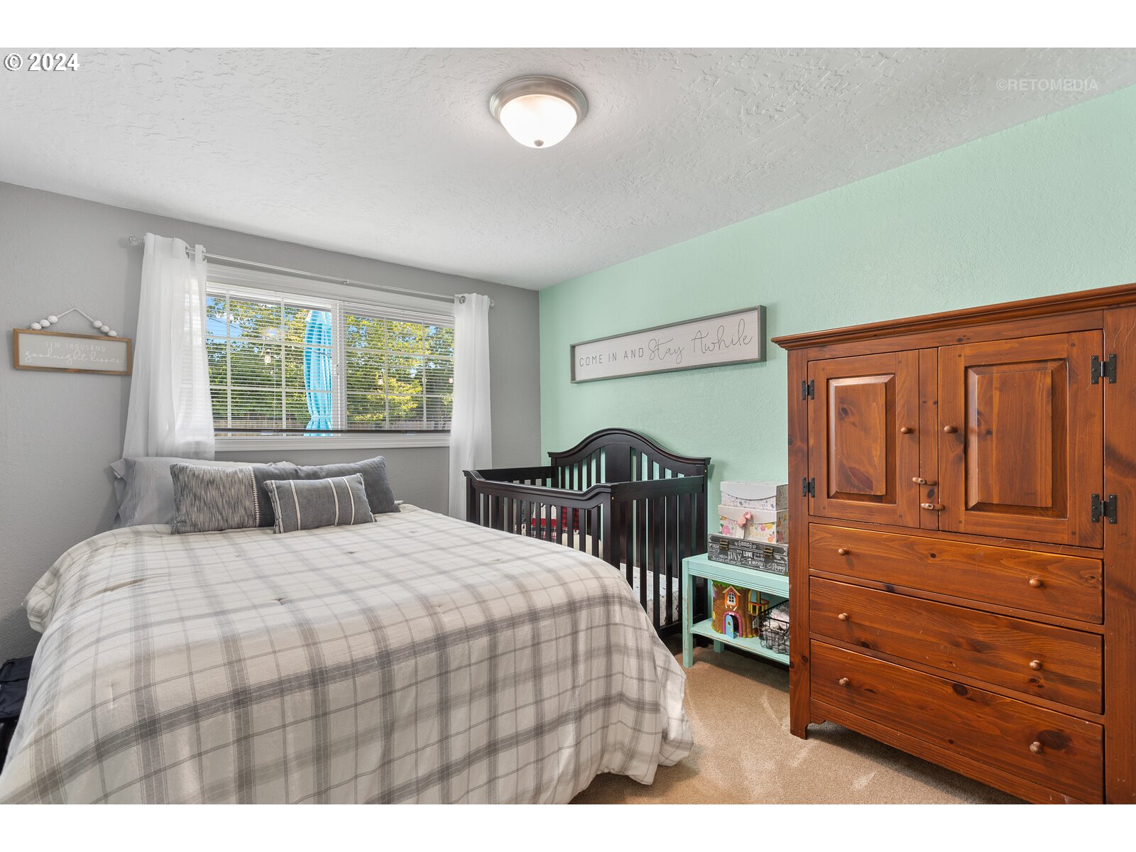780 South Elm Court Canby, OR 97013 - Photo 22 of 32 a bedroom with a bed a dresser and a window