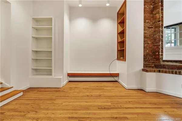 a view of empty room with window and wooden floor