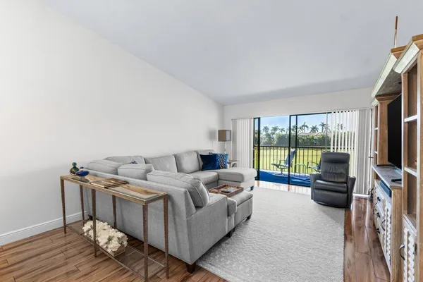 a living room with furniture a flat screen tv and a floor to ceiling window