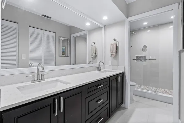 a bathroom with a double vanity sink mirror double and shower