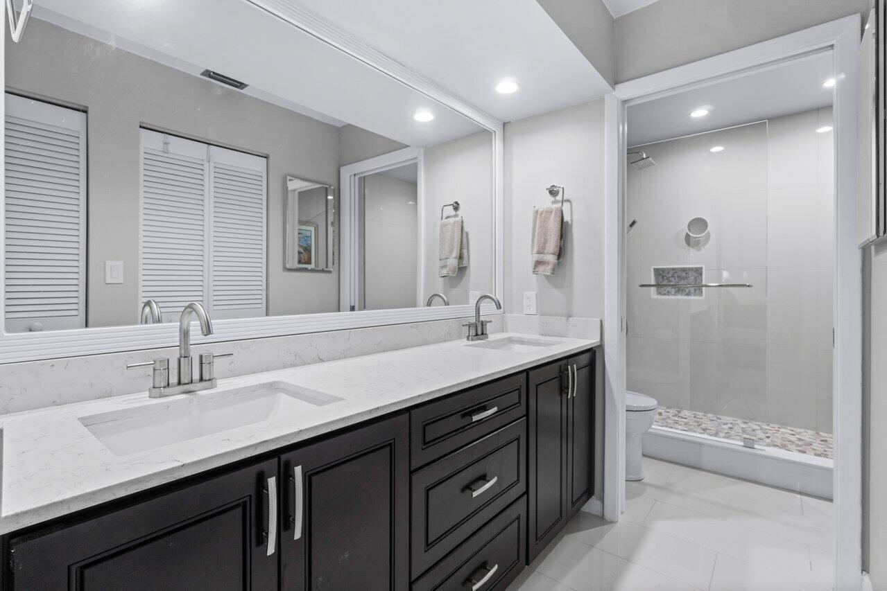 5120 Golfview Court, Unit 1722 Delray Beach, FL 33484 - Photo 13 of 46 a bathroom with a double vanity sink mirror double and shower