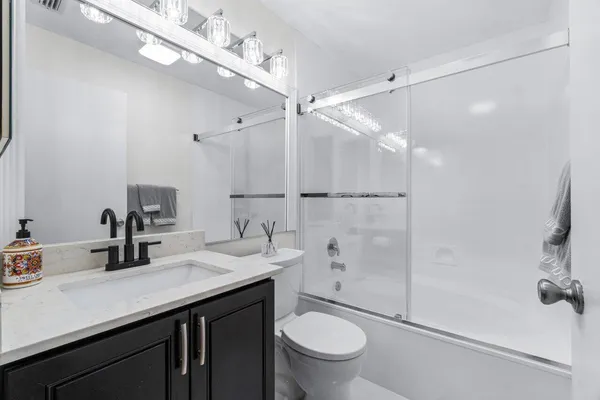 a bathroom with a sink a toilet and shower