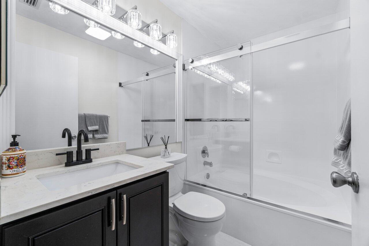 5120 Golfview Court, Unit 1722 Delray Beach, FL 33484 - Photo 16 of 46 a bathroom with a sink a toilet and shower