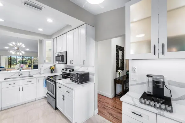 a kitchen with white cabinets and appliances