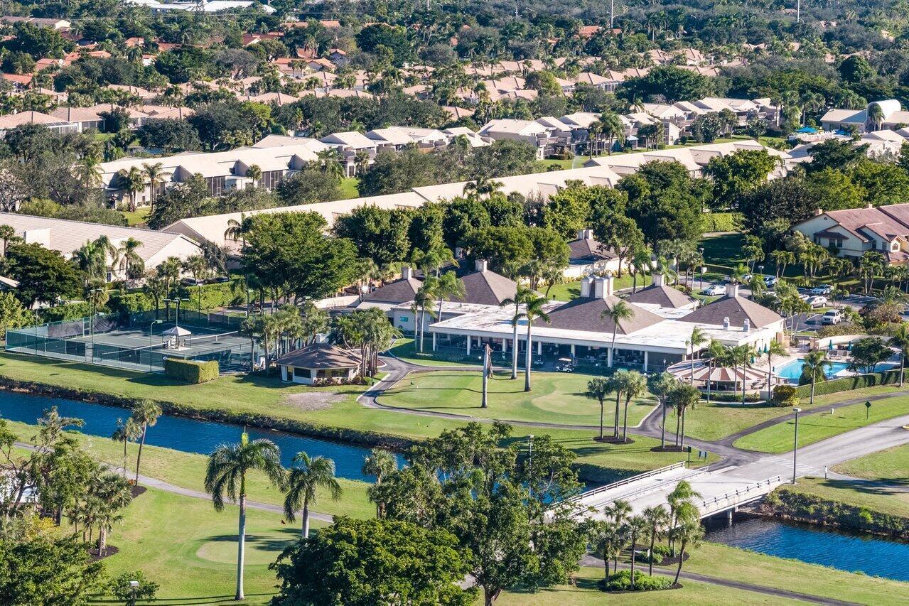 5120 Golfview Court, Unit 1722 Delray Beach, FL 33484 - Photo 30 of 46 an aerial view of a swimming pool with lawn chairs and large trees