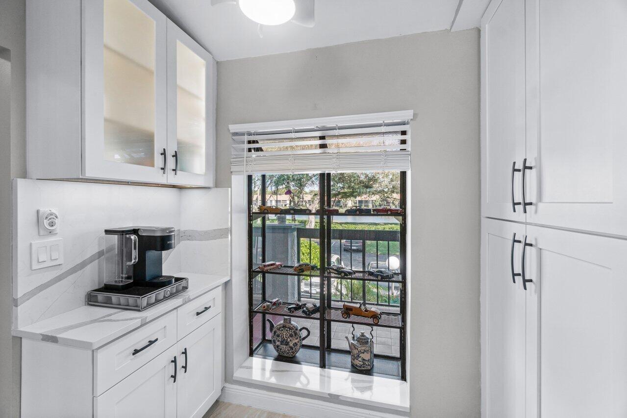 5120 Golfview Court, Unit 1722 Delray Beach, FL 33484 - Photo 4 of 46 a kitchen with a stove and a white cabinet