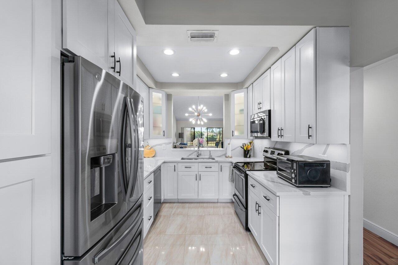 5120 Golfview Court, Unit 1722 Delray Beach, FL 33484 - Photo 7 of 46 a kitchen with a refrigerator and a sink