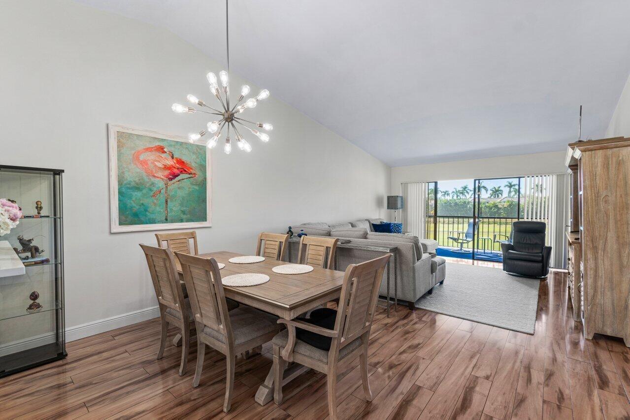 5120 Golfview Court, Unit 1722 Delray Beach, FL 33484 - Photo 10 of 46 a view of a dining room with furniture wooden floor and chandelier