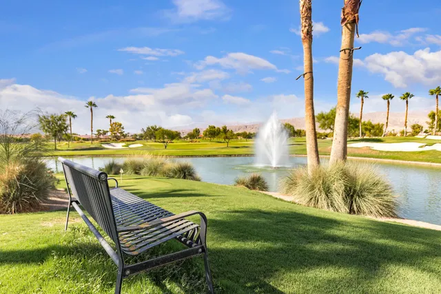a view of a lake with a table and chairs in front of it