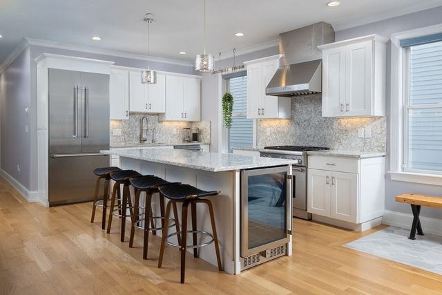 a kitchen with granite countertop a stove a sink and a refrigerator