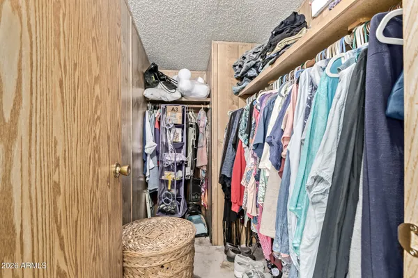 a view of walk in closet with clothes and shoes