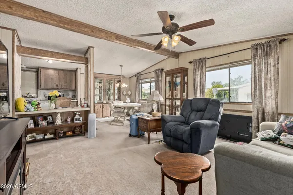 a living room with furniture a ceiling fan and a large window