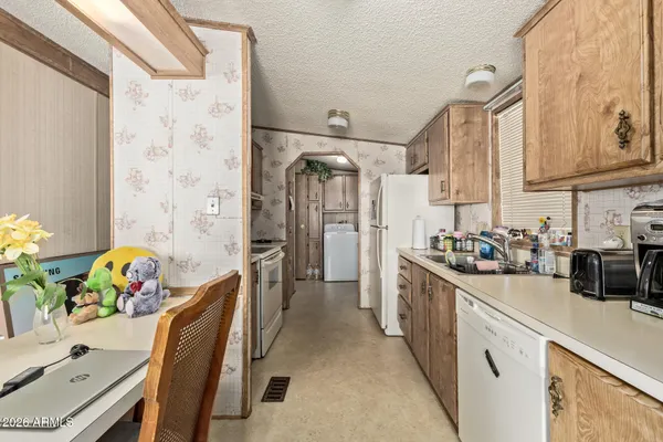 a kitchen with stainless steel appliances a white stove top oven a dining table and chairs