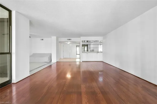 a view of empty room with wooden floor