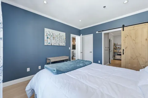 a bedroom with a large bed and a chandelier