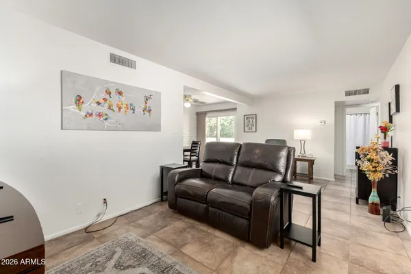 a living room with furniture a table and chairs with wooden floor
