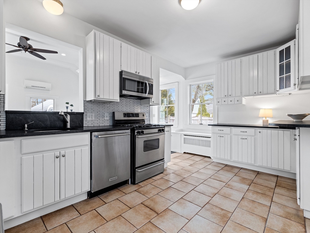 41 Rice Street Wellesley, MA 02482 - Photo 8 of 24 a kitchen with white cabinets stainless steel appliances and a window