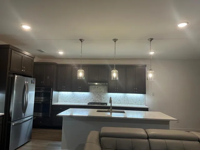 a kitchen with stainless steel appliances granite countertop a refrigerator and a sink